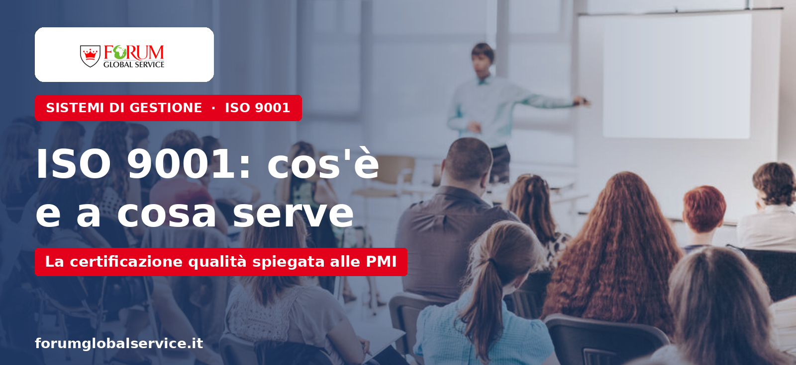 Relatore in piedi davanti a una platea in aula durante un corso aziendale — certificazione ISO 9001 per le PMI